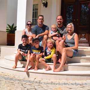 Unmumsy Mum and family sat on stairs at Tots To Travel property